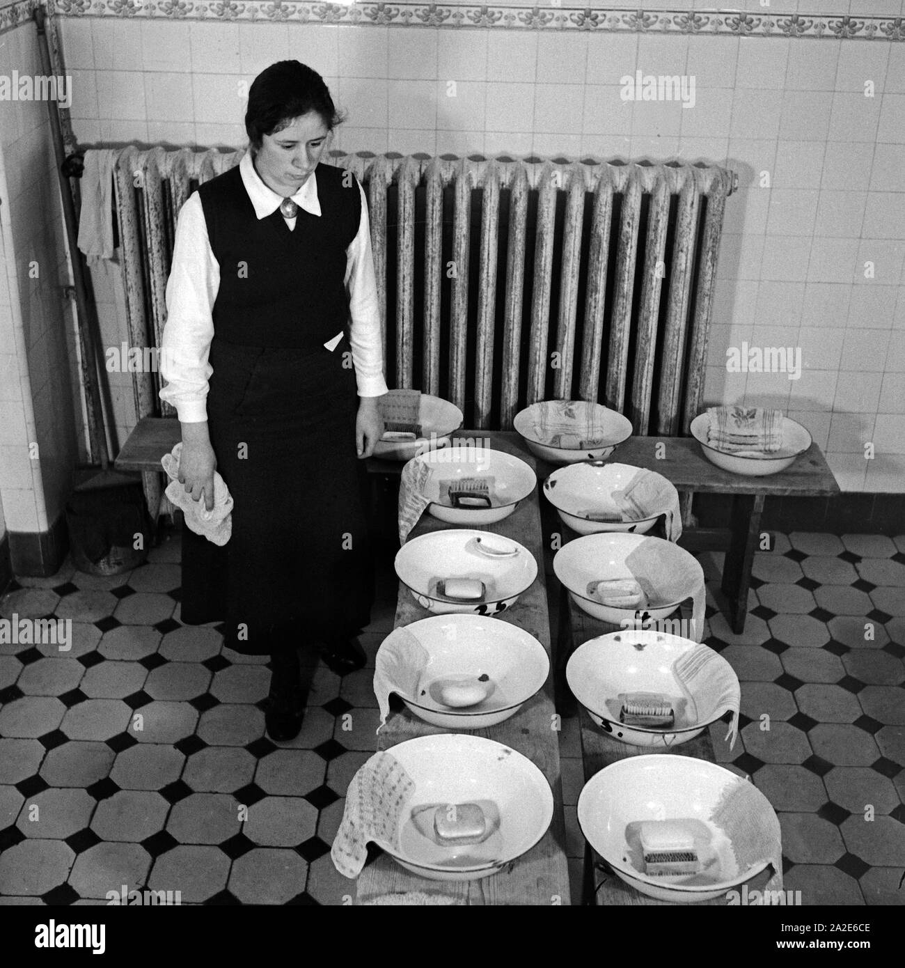 Eine Frau hat Waschschüsseln vorbereitet beim weiblichen Arbeitsdienst in Molkenberg bei Fürstenwalde, Deutschland 1930er Jahre. A woman prepared some washing dishes at the female workforce group of Molkenberg, Germany 1930s. Stock Photo