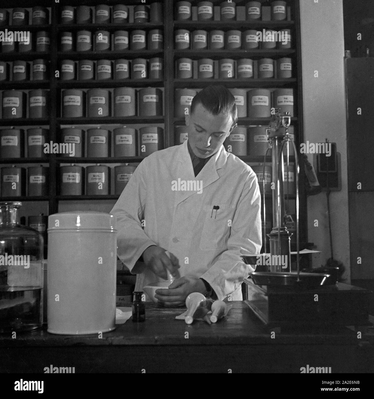 Ein Apothekerlehrling stellt ein Medikament zusammen, Deutschland 1930er Jahre. A pharmacy trainee miing and producing medicine, Germany 1930s. Stock Photo