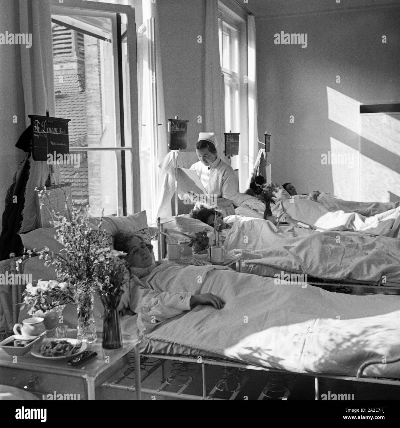 Eine Krankenschwester kümmet sich um kranke Frauen im Mütterheim Dresden auf Schloß Dittersbach, Deutschland 1930er Jahre. A nurse caring for sick women at the rest centre for mothers at Dittersbach castle near Dresden, Germany 1930s. Stock Photo