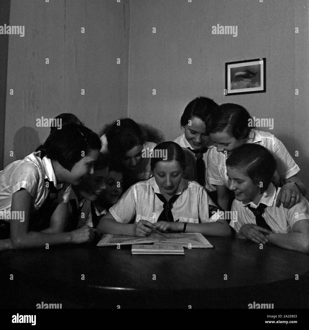Eine Gruppe BdM Mädchen sitzt über einem Atlas in Berlin Pankow, Deutschland 1930er Jahre. A group of BdM girls studying a map at Berlin Pankow, Germany 1930s. Stock Photo
