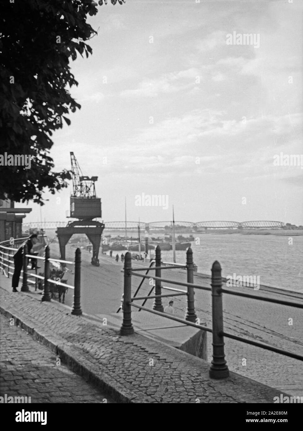 Im Hafen von Tilsit in Ostpreußen mit Blick auf den Fluß Memel und die Eisenbahnbrücke, 1930er Jahre. At the harbor of Tilsit with the river Memel and the railway bridge, East Prussia, 1930s. Stock Photo