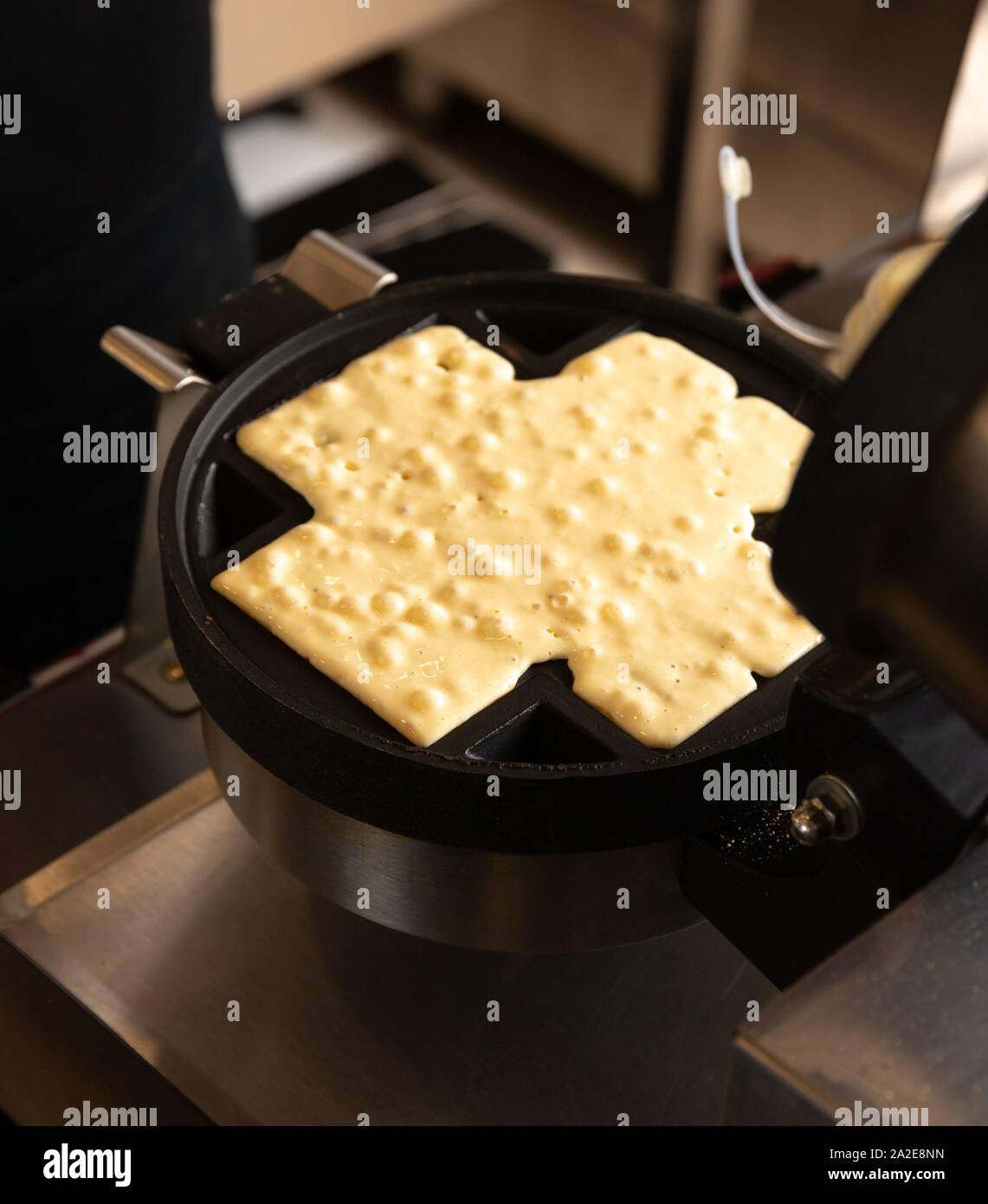 Making waffles on dark waffle iron, action shots Stock Photo Alamy