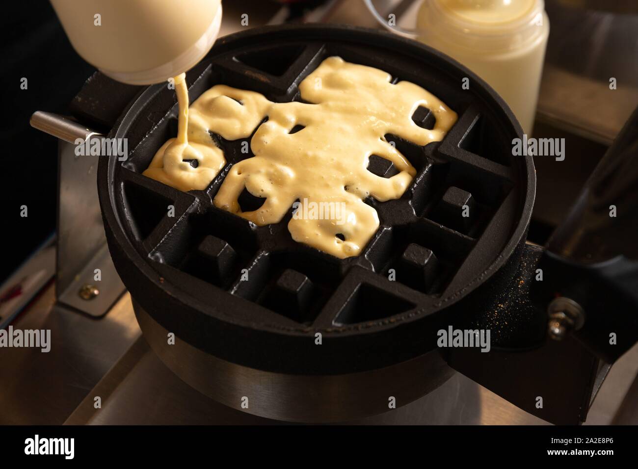 Making waffles on dark waffle iron, action shots Stock Photo Alamy