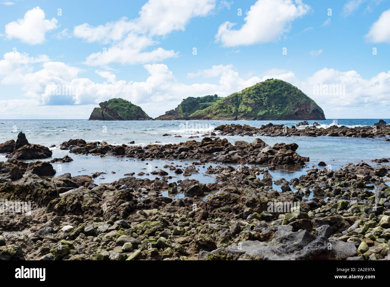 View of the Islet of Vila Franca do Campo from a volcanic lava rock beach on the southern coast of São Miguel Island in the Azores. Stock Photo