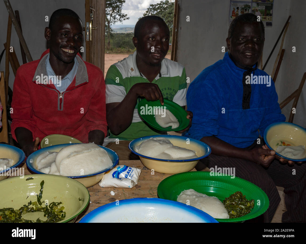 Malawian people eating Nshima / Nsima - a cornmeal porridge made in Africa Stock Photo