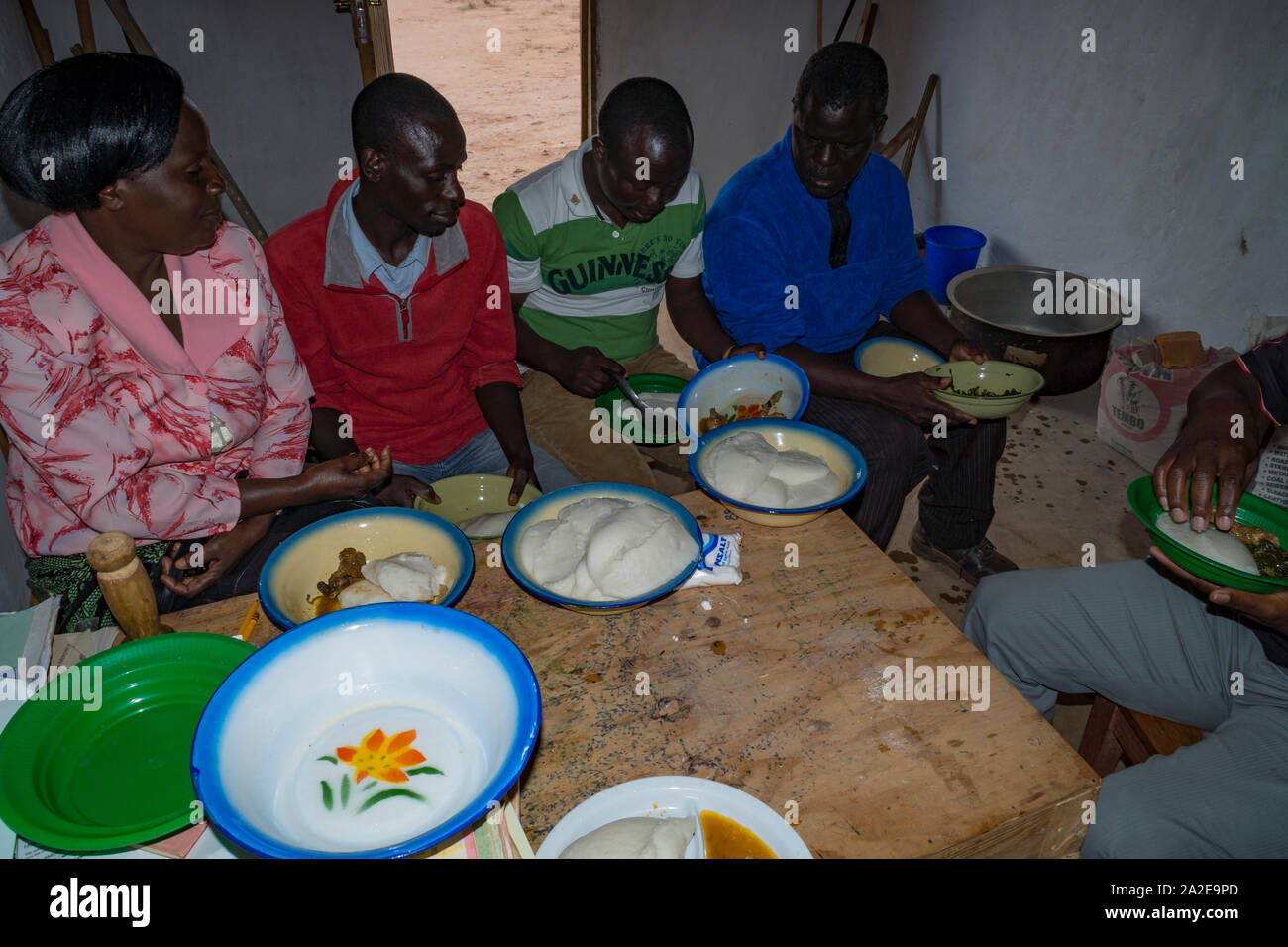 Malawian people eating Nshima / Nsima - a cornmeal porridge made in Africa Stock Photo