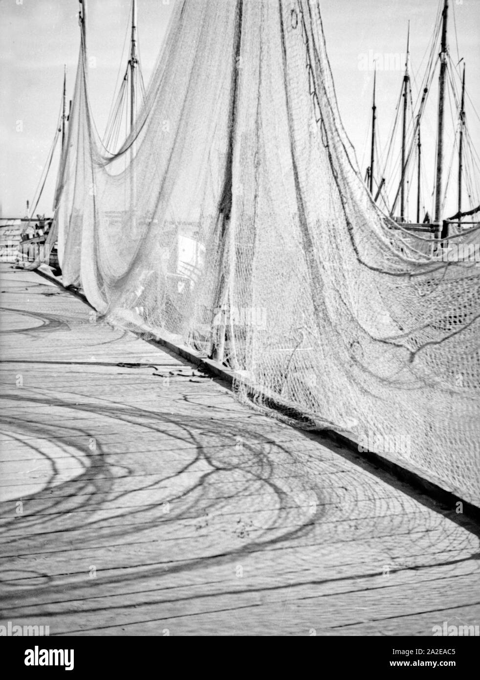 Fischernetze sind am Anlegesteg im Hafen ausgebreitet, Ostpreußen, 1930er Jahr. Fisherman nets at a jetty in a harbor of East Prussia, 1930s. Stock Photo