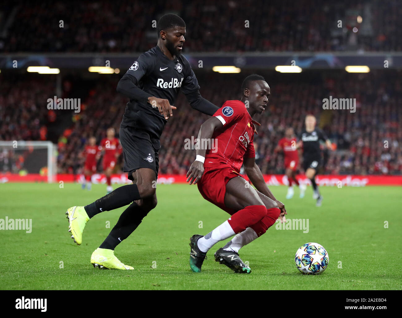 Red Bull Salzburg's Jerome Onguene (left) and Liverpool's Sadio Mane battle for the ball during the UEFA Champions League Group E match at Anfield, Liverpool. Stock Photo
