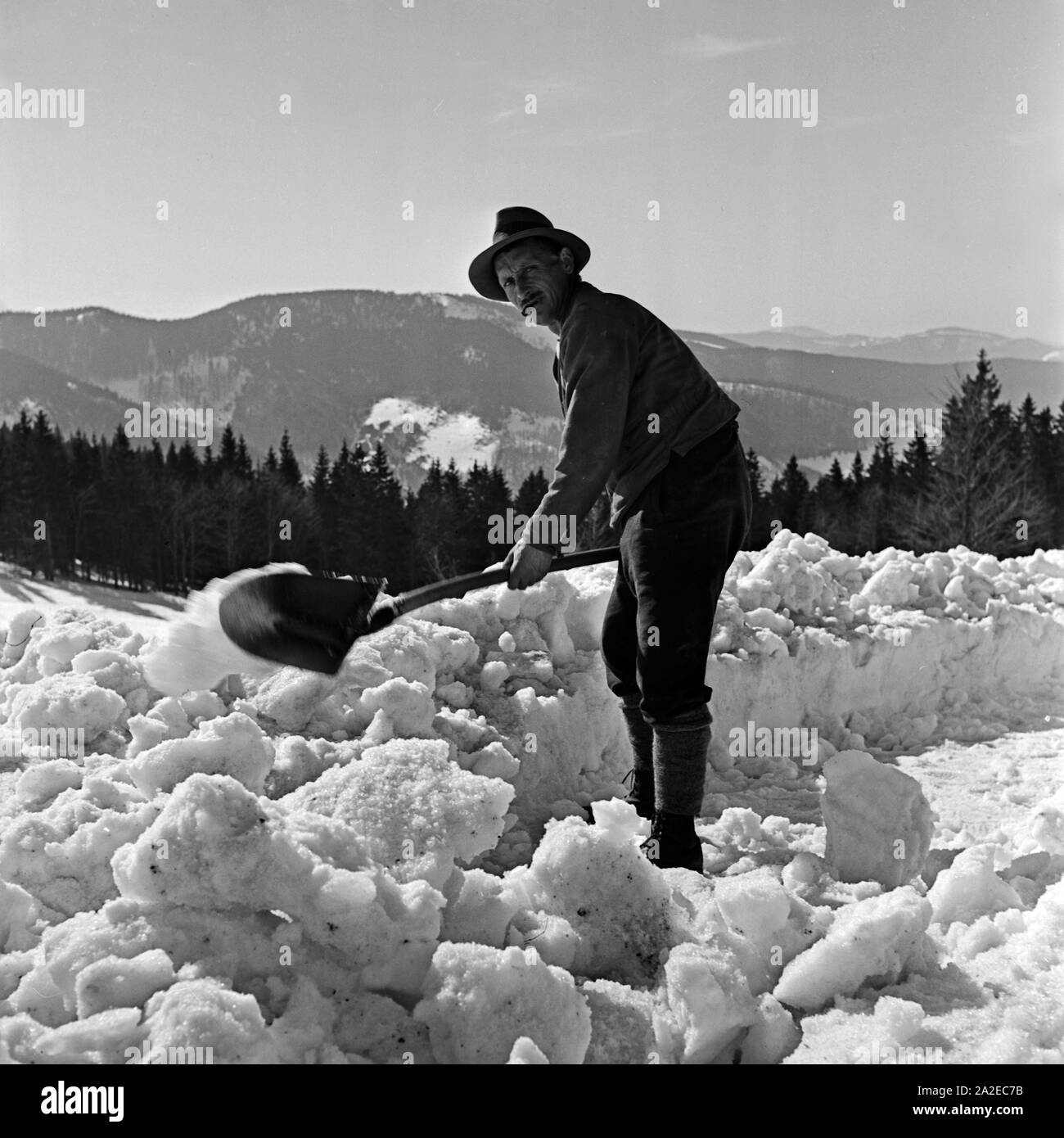 Ein Mitarbeiter des Feldbergerhof Hotels beim Schneeschippen, Deutschland 1930er Jahre. A staff member of the Feldbergerhof hotel cleaning away the snow, Germany 1930s. Stock Photo