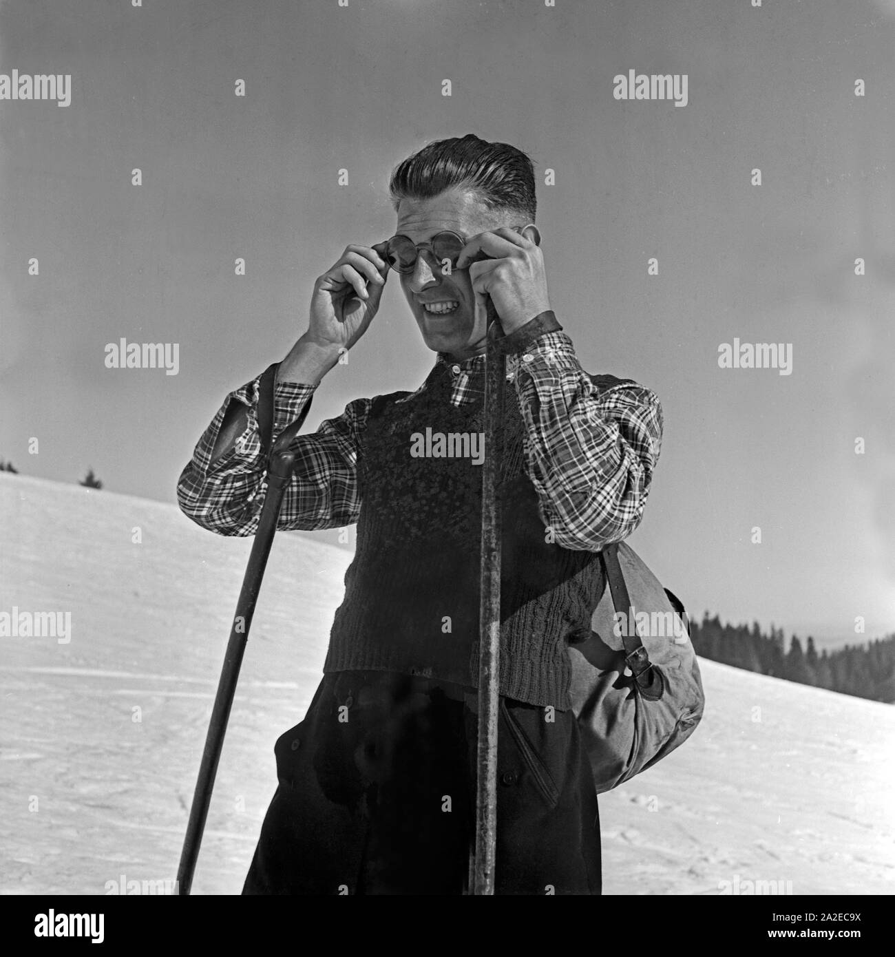 Ein Skifahrer richtet sich seine Sonnenbrille, Deutschland 1930er Jahre. A  ski tourist adjusting is sunglasses, Germany 1930s Stock Photo - Alamy