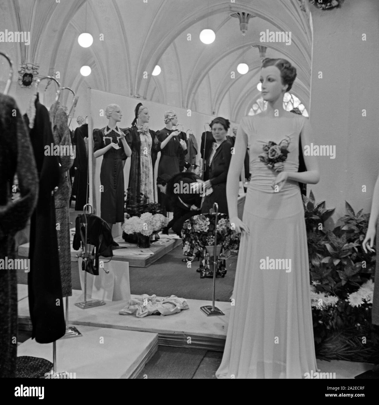 Einkäufer sehen sich die Ausstellung im Rahmen der ADEFA Modenschau an, Deutschland 1930er Jahre. Purchasing agents strolling through the exhibition at the ADEFA fashion show, Germany 1930s. Stock Photo