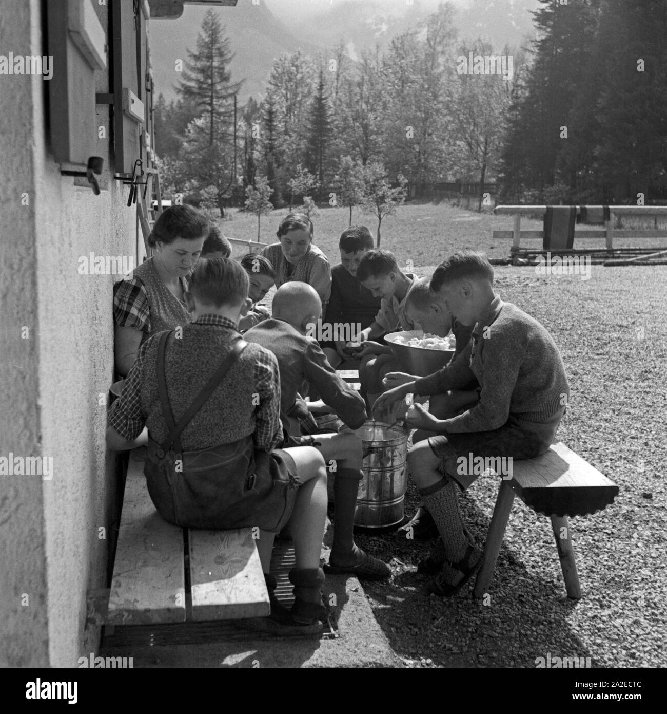 Jungen helfen der Herbergsmutter der Adolf-Hitler-Jugendherberge in Berchtesgaden beim Kartoffelnschälen, Deutschland 1930er Jahre. Boys helping the hostel warden peeling potatoes at the Adolf Hitler youth hostel at Berchtesgaden, Germany 1930s. Stock Photo