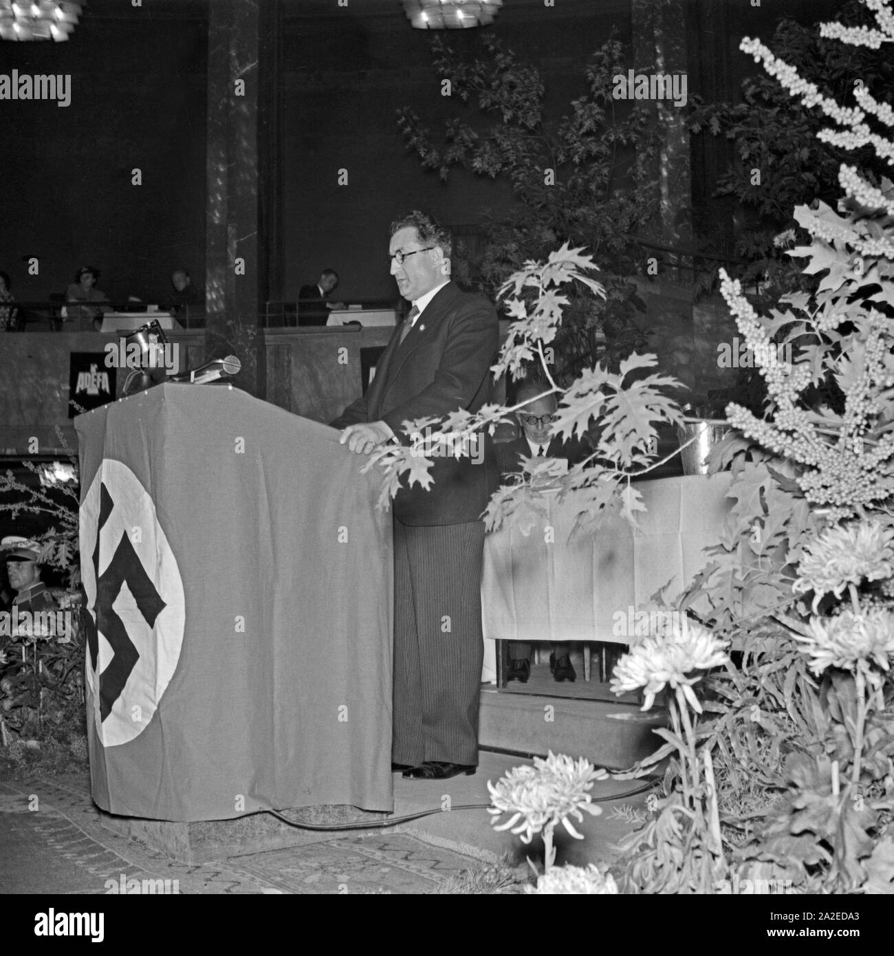 Ein Funktionär hält eine Rede im Rahmen der ADEFA Modenschau, Deutschland 1930er Jahre. An official delivering a speech at the ADEFA fashion show, Germany 1930s. Stock Photo