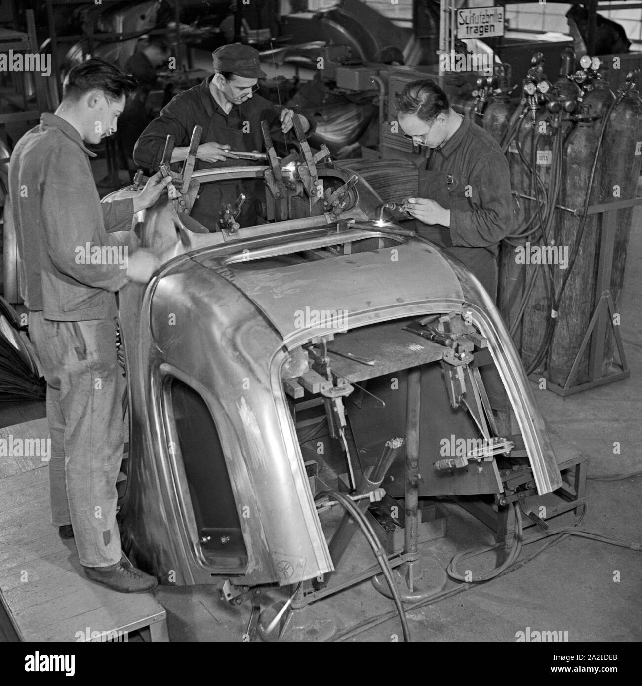 Arbeiter der Ford Werke in Köln Niehl bei der Reparatur an alten Karosserien, Deutschland 1930er Jahre. Workers repairing old chassis at the Ford factory at Cologne, Germany 1930s. Stock Photo