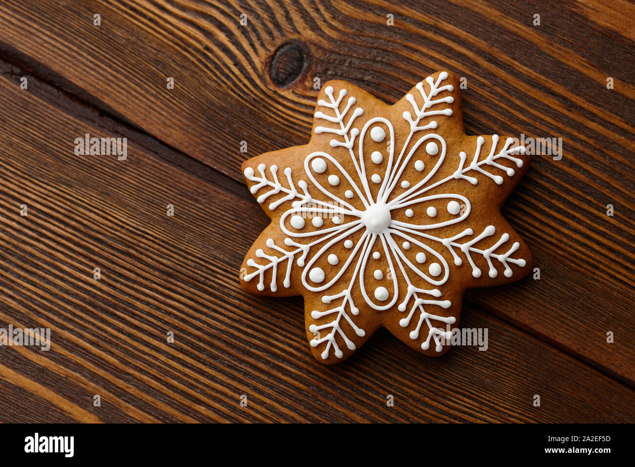 Christmas gingerbread snowflake on wooden texture Stock Photo