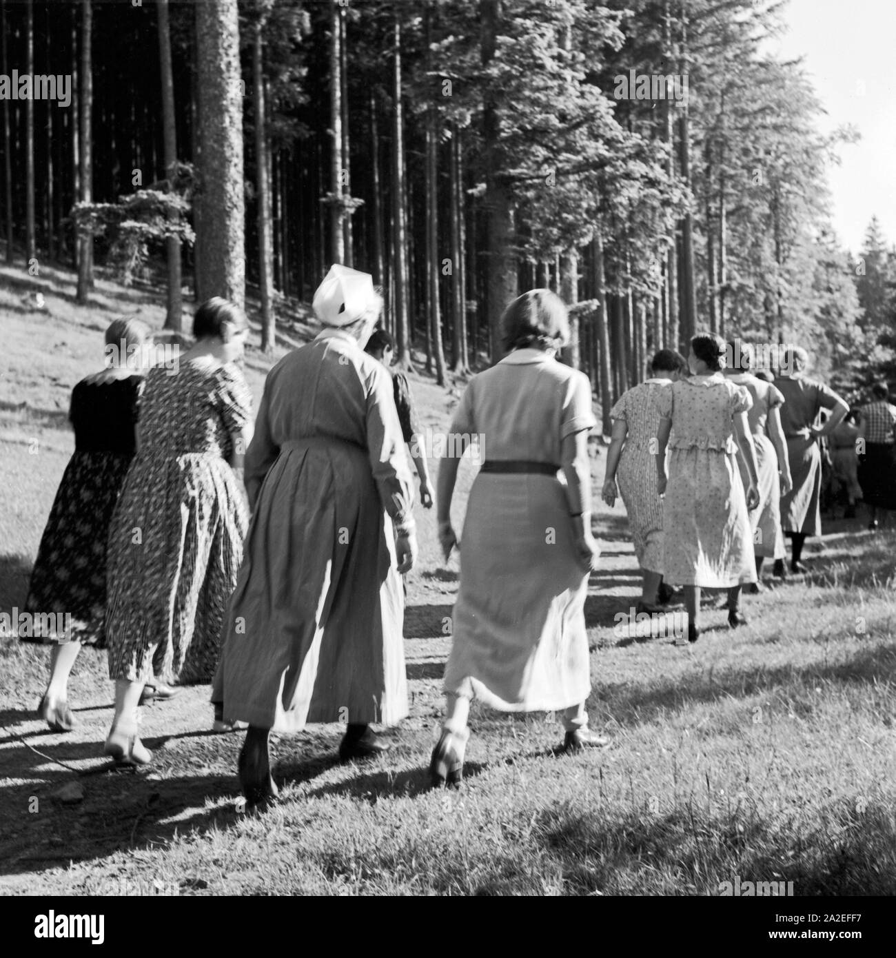 Eine Krankenschwester mit einer Gruppe Frauen bei einer Wanderung im Rahmen eines Aufenthalts im Mutter und Kind Heim in Tabarz, Thüringer Wald, 1930er Jahre. A nurse with a group of women wandering through the forest while being in treatment at a women and child recreation home at Tabarz, Thuringia, 1930s. Stock Photo