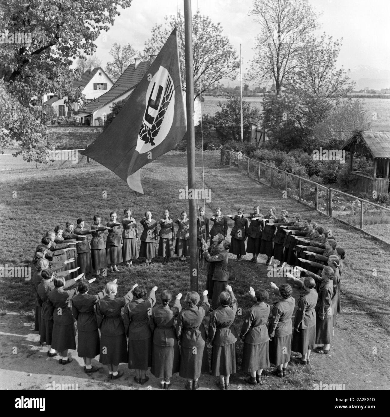 Frauen beim Morgenappell und Flagge hissen beim Frauenarbeitsdienst in Kempten, Deutschland 1930er Jahre. Women at daily muster and raising the flag at female workforce at Kempten, Germany 1930s. Stock Photo