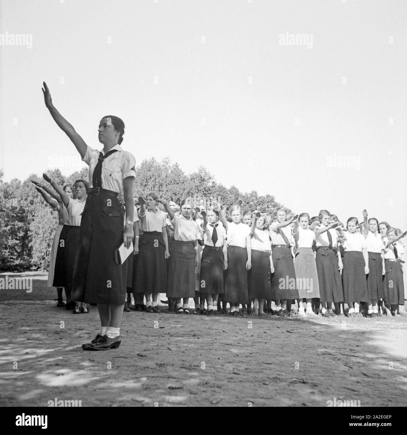 Eine BDM Jungmädelschar grüßt beim Morgenappell mit dem deutschen Gruß im Freizeitlager Altenhof am Werbellinsee in Brandenburg, 1930er Jahre. A group of BDM girls greeting with the Hitlergruss at the morning roll call at the leisure camp at Altenhof, Brandenburg, 1930s. Stock Photo