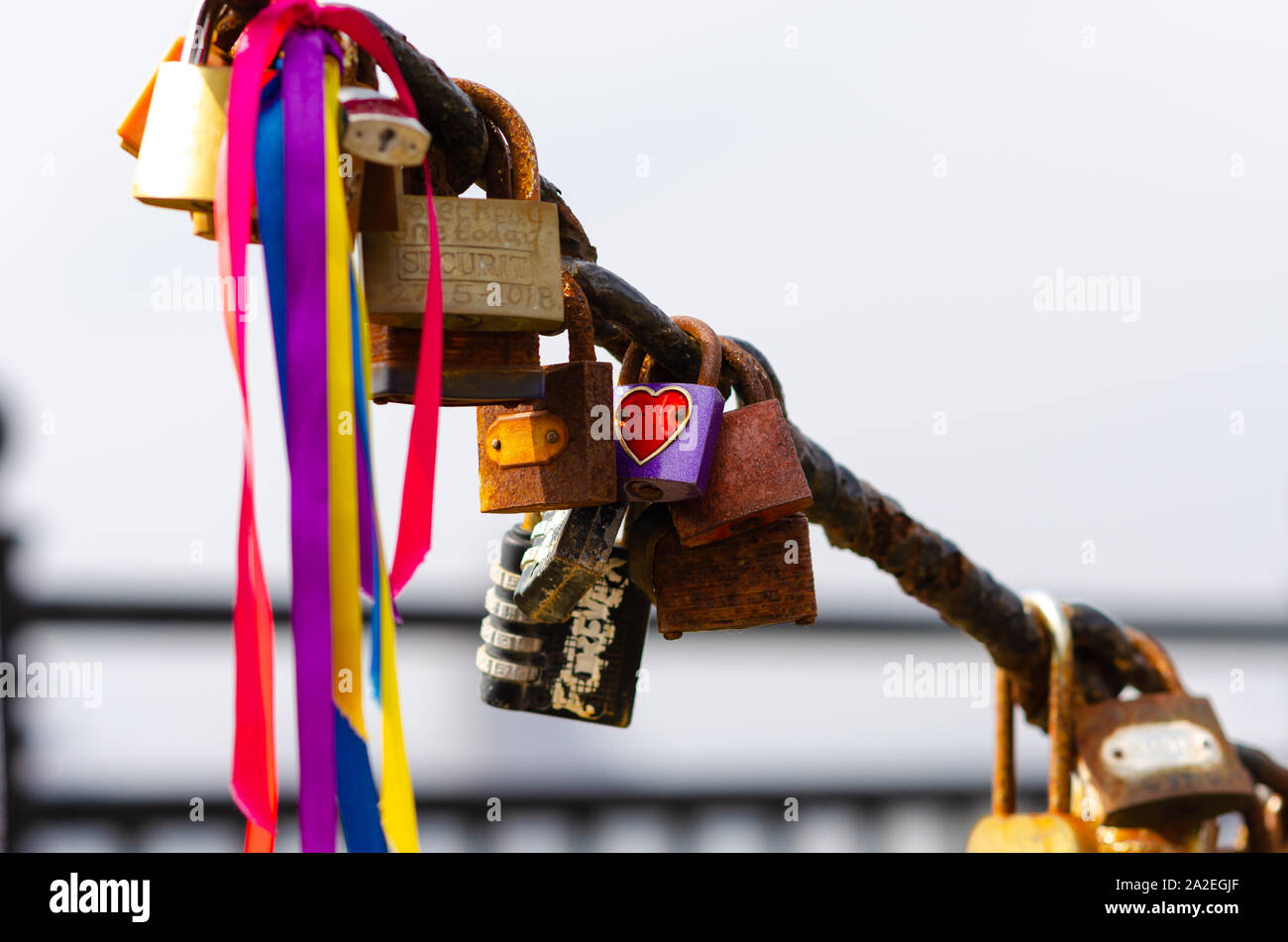 Love Locks at Albert Dock,  Liverpool. The fence chains are full of contrast: old rusted and brand new padlocks of different shape and sizes. Stock Photo