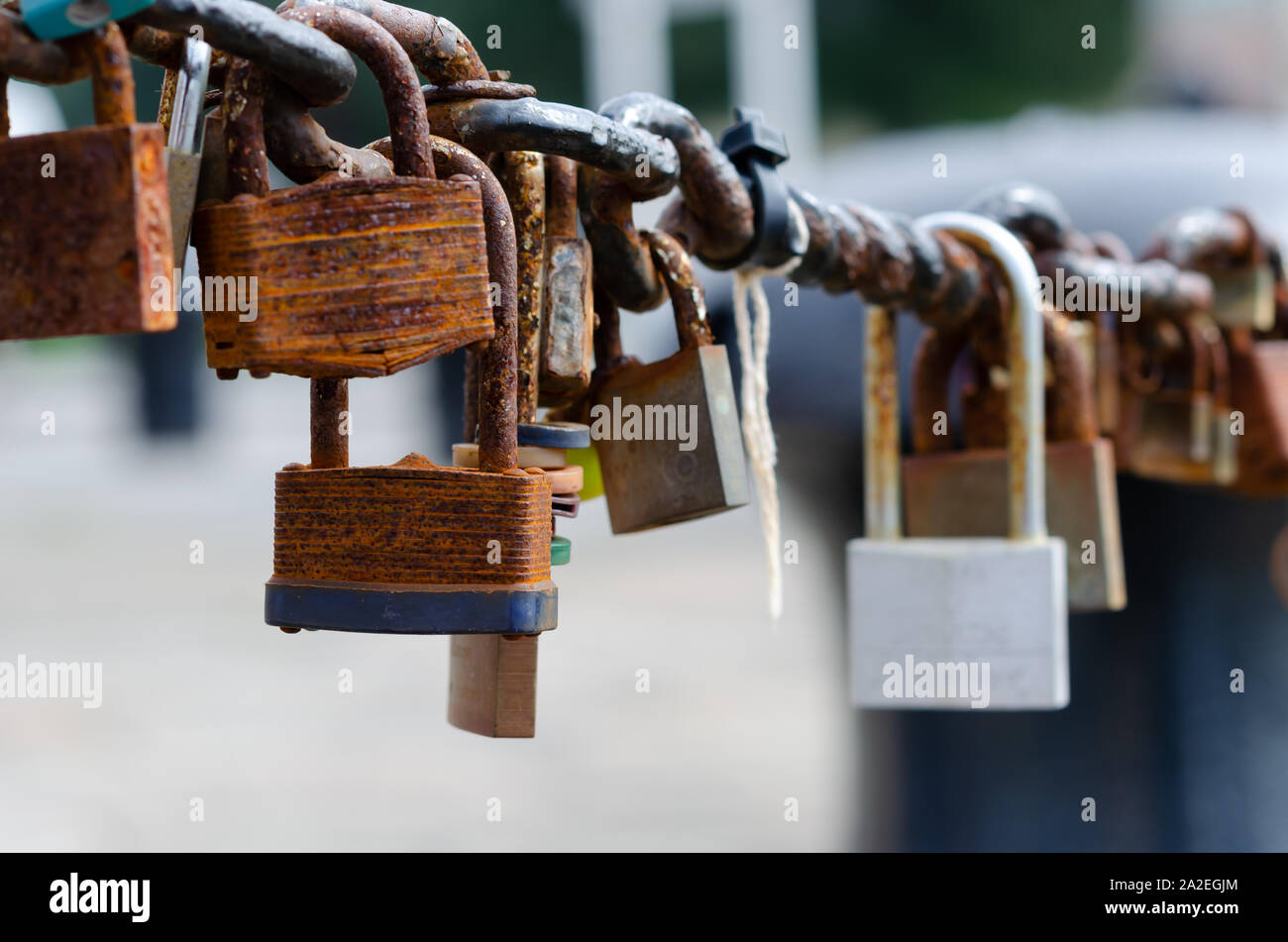 Love Locks at Albert Dock,  Liverpool. The fence chains are full of contrast: old rusted and brand new padlocks of different shape and sizes. Stock Photo