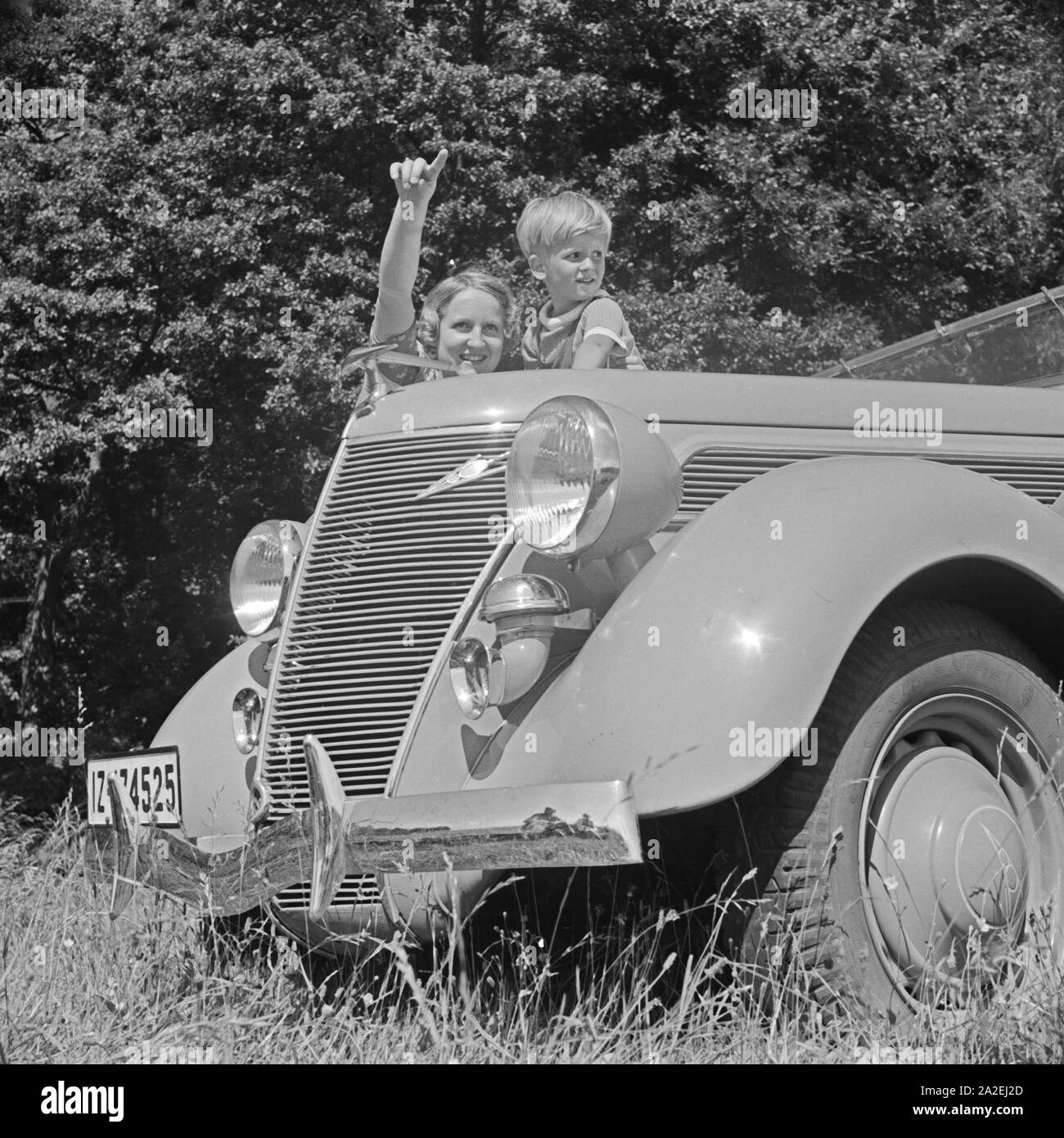 https://c8.alamy.com/comp/2A2EJ2D/eine-junge-frau-und-ein-junge-an-der-khlerhaube-eines-automobils-deutschland-1930er-jahre-a-young-woman-and-a-boy-at-the-bonnet-of-a-car-germany-1930s-2A2EJ2D.jpg