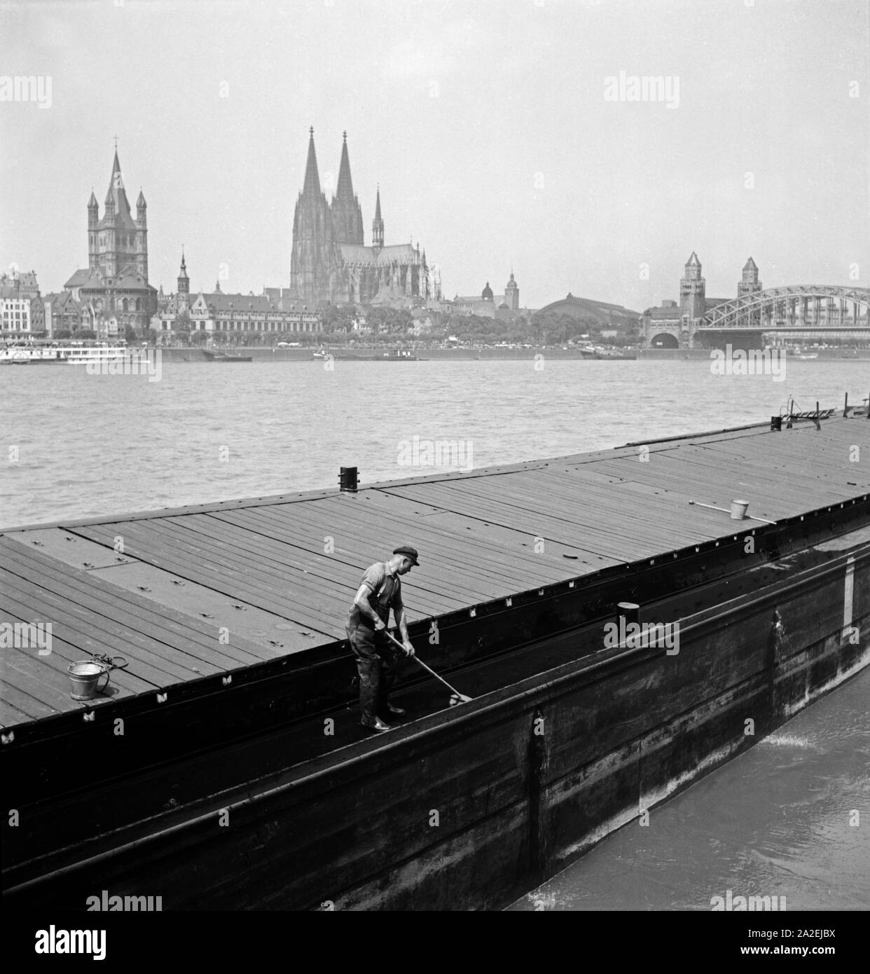 Blick auf die Stadt Köln, mit Dom und Kirche Groß St. Martin, mit einem Frachtkahn im Vordergrund, 1930er Jahre Stock Photo