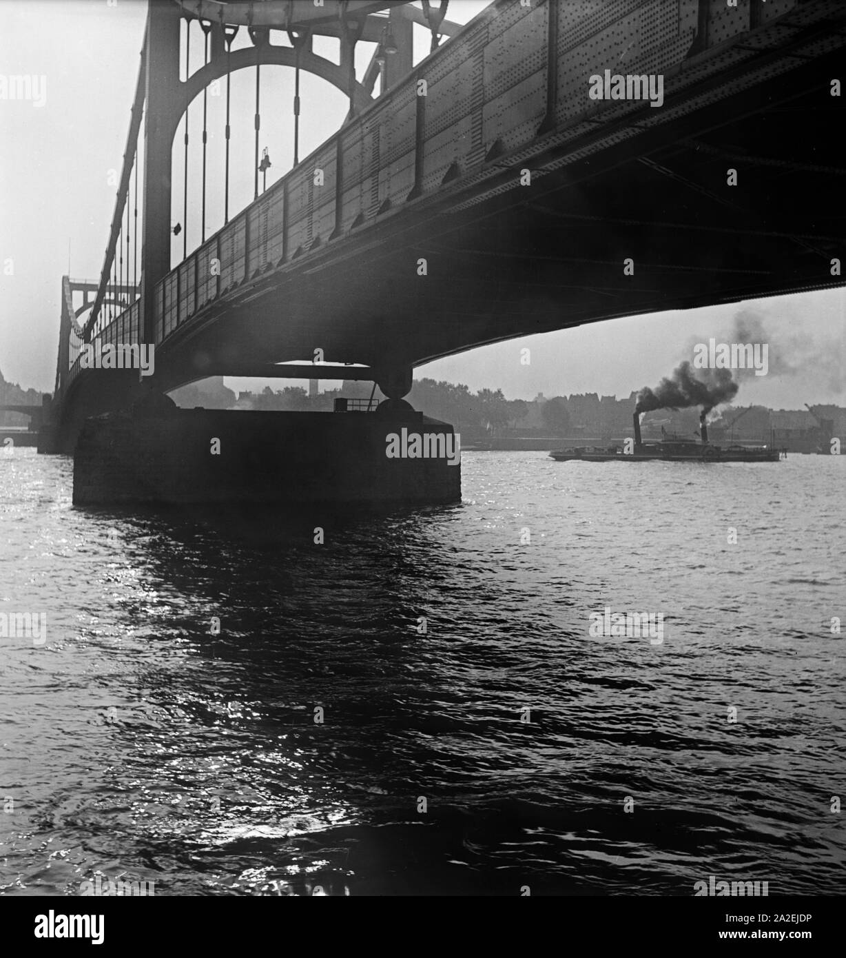 Blick unter der Deutzer Hängebrücke auch Hindenburgbrücke, auf die Flußschifffahrt in Köln, 1930er Jahre Stock Photo
