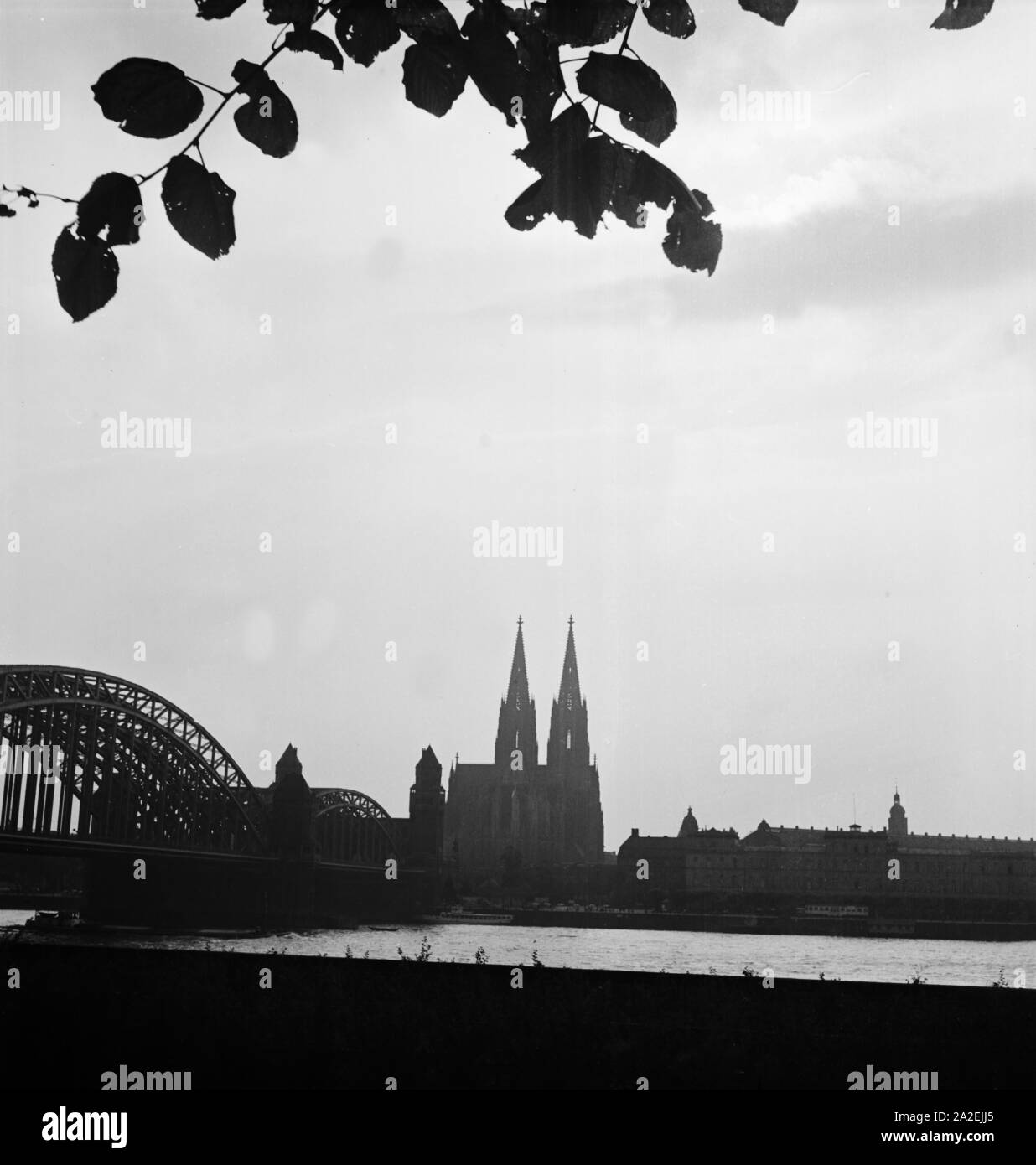 Blick von der rechten Rheinseite in Deutz auf die Silhouette der Hohenzollernbrücke, Dom und Hauptbahnhof, 1930er Jahre, Stock Photo