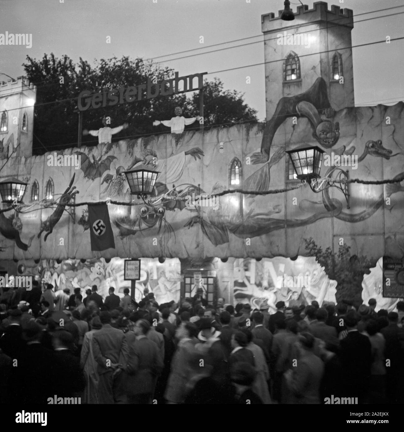 Besucher drängen sich vor der Geisterbahn auf der Festwiese in Berlin Stralau, Deutschland 1930er Jahre. Crowd in front of the haunted house at the Berlin Stralau annual fair, Germany 1930s. Stock Photo