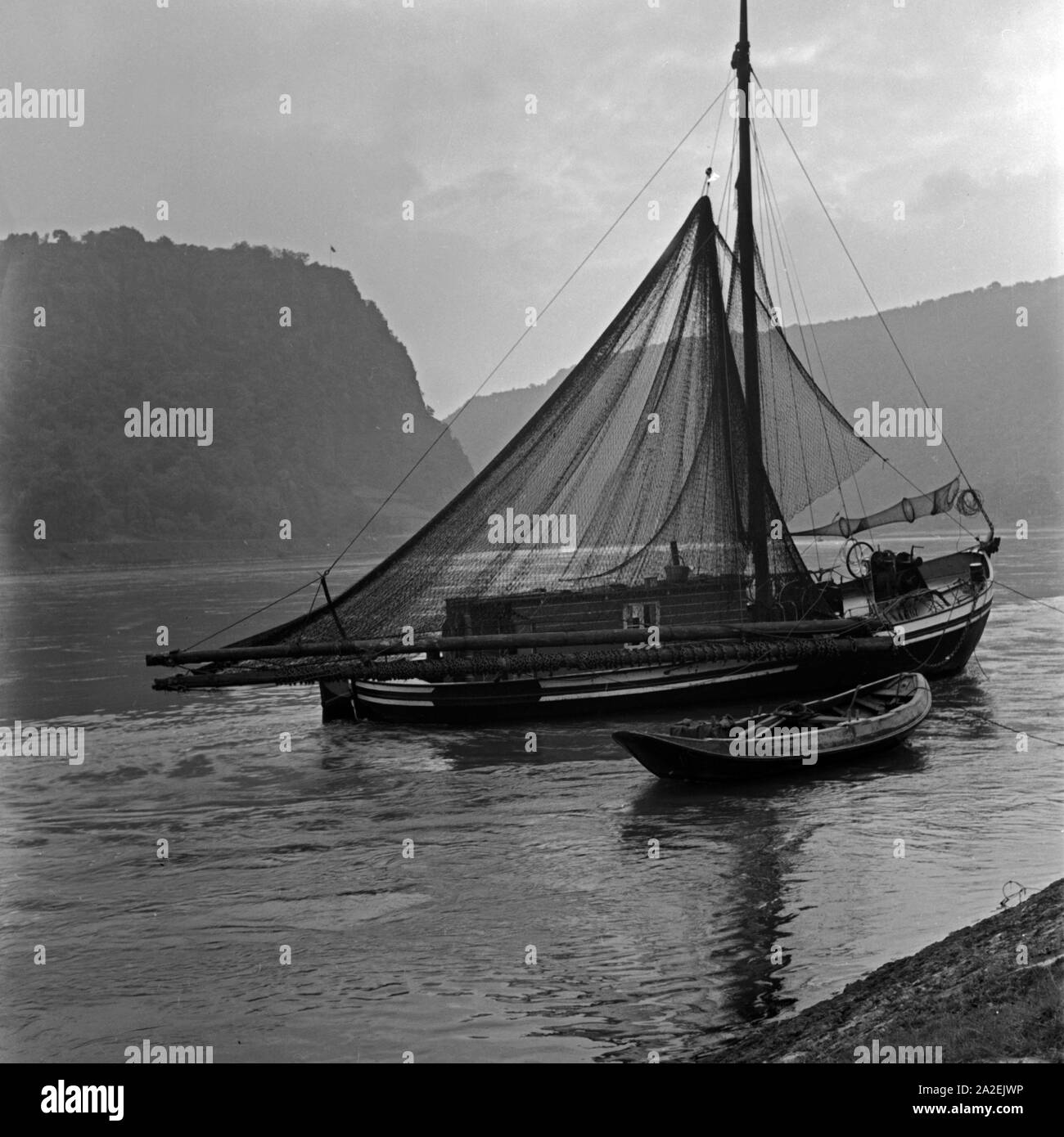 Ein Fischerboot auf dem Rhein unterhalb der Loreley, Deutschland 1930er Jahre. A fisherboat at river Rhine near the Loreley rock, Germany 1930s. Stock Photo