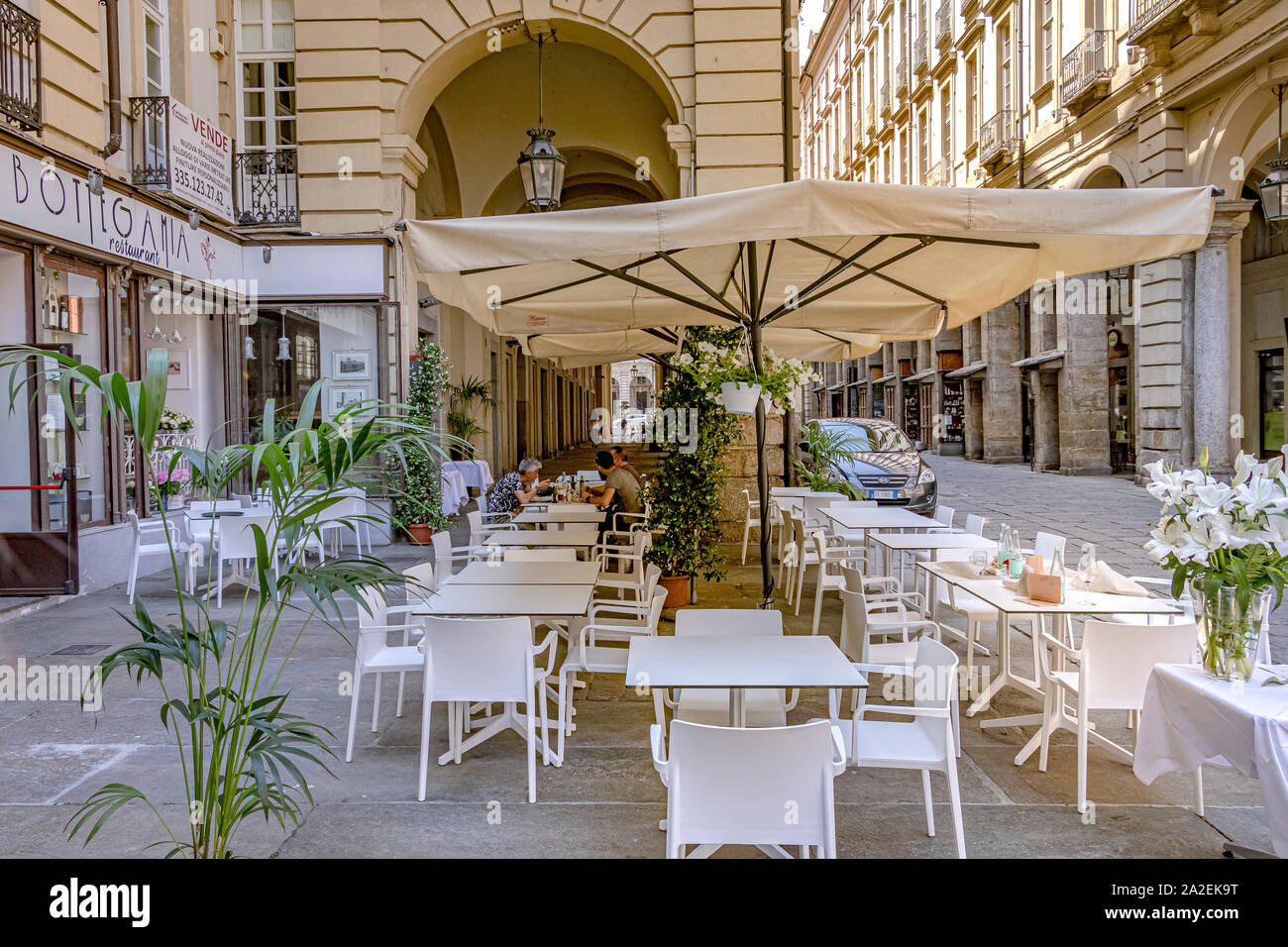 People eating lunch at the tables and chairs outside Ristorante Bottega Mia a restaurant on Via Palazzo di Città ,Turin ,Italy Stock Photo