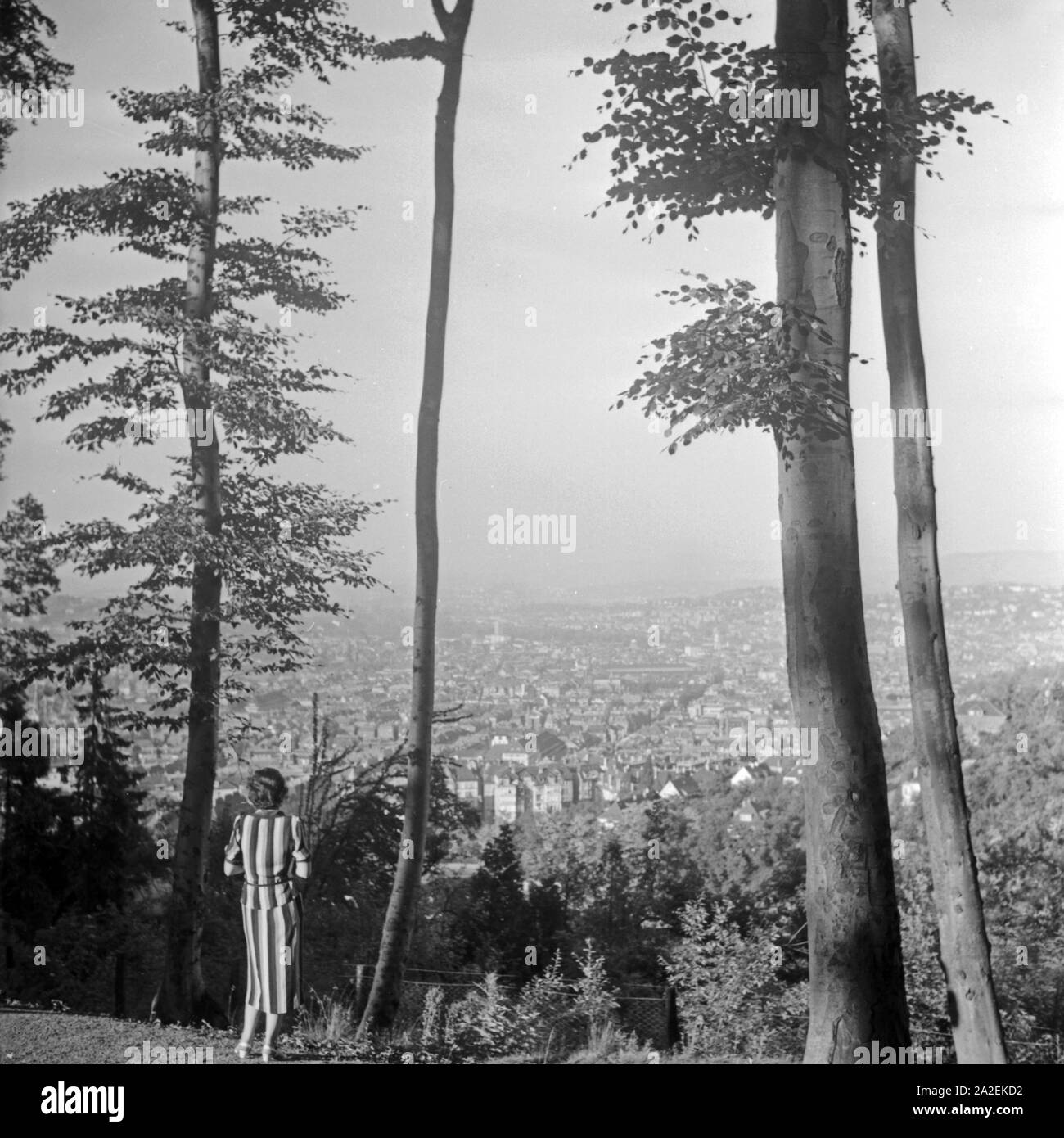 Eine Frau steht auf einer Anhöhe und blickt auf die Stadt Stuttgart, Deutschland 1930er Jahre. A woman standing on a hill and viewing the city of Stuttgart, Germany 1930s. Stock Photo