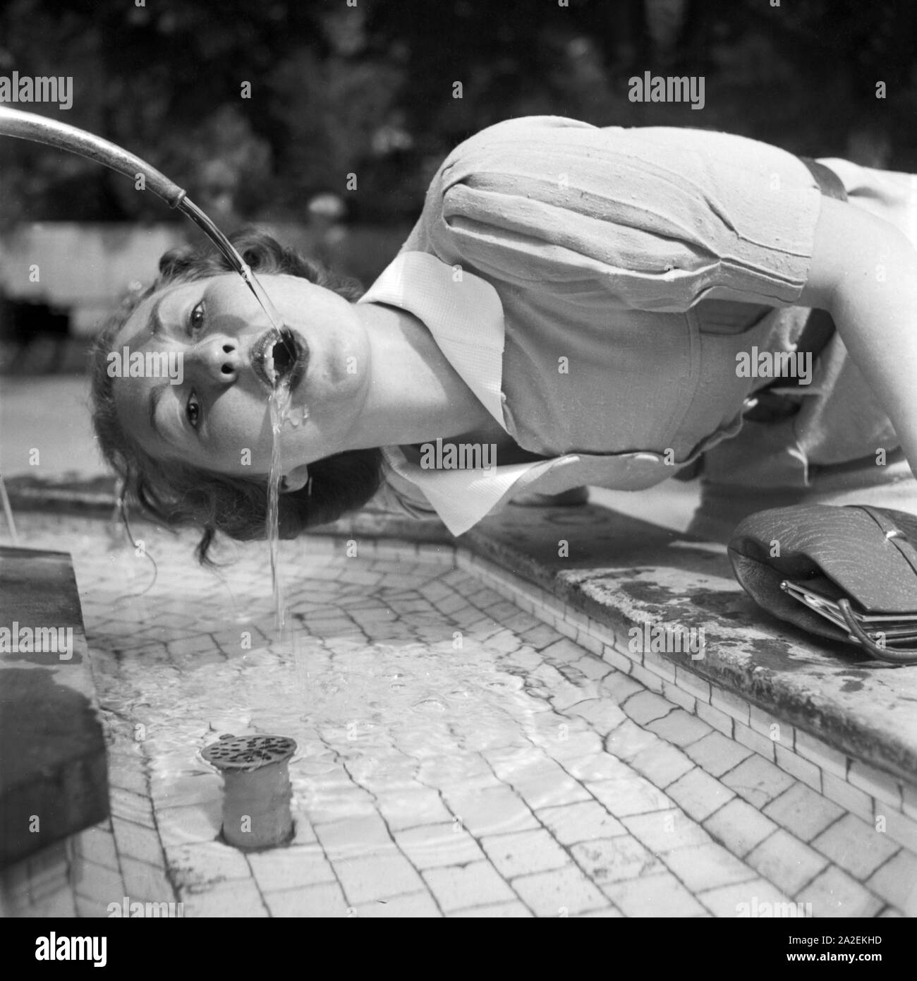 Eine Frau trinkt aus einem Brunnen in Bad Cannstatt bei Stuttgart, Deutschland 1930er Jahre. A woman drinking from a well at Bad Cannstatt near Stuttgart, Germany 1930s. Stock Photo