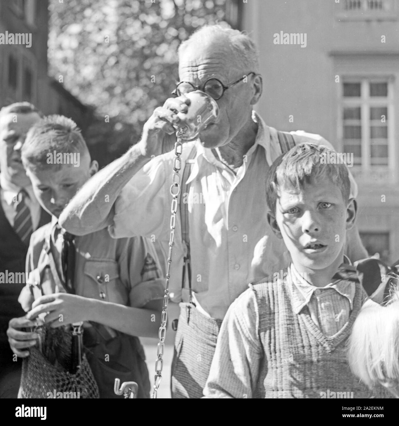 Kurgäste trinken gesundes Wasser aus einem Brunnen in Bad Cannstatt, Deutschland 1930er Jahre. Spa guests drinking wellness water from a well at Bad Cannstatt, Germany 1930s. Stock Photo