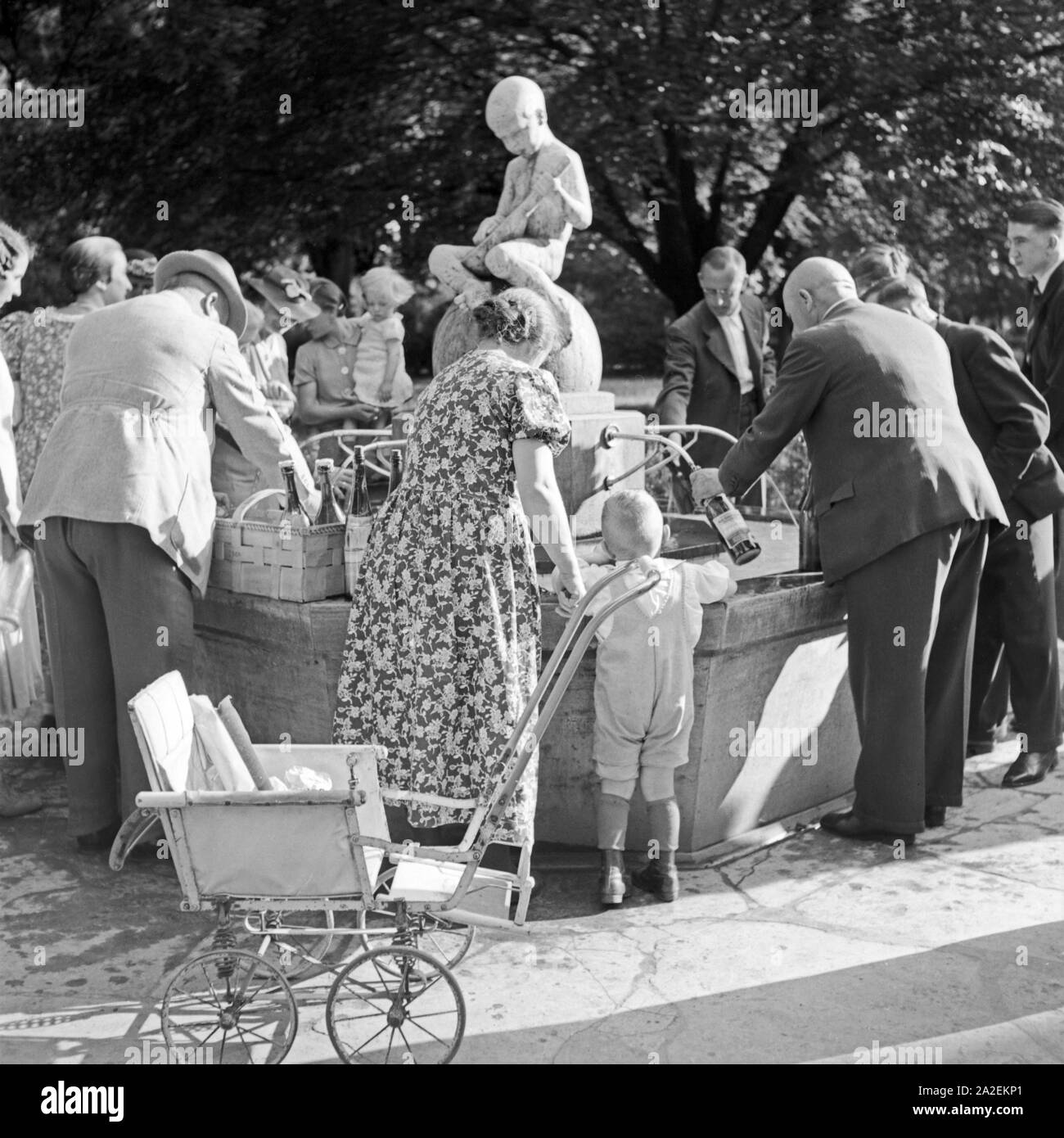 Kurgäste füllen sich gesundes Wasser aus einem Brunnen in Bad Cannstatt ab, Deutschland 1930er Jahre. Spa guests taking wellness water from a well at Bad Cannstatt, Germany 1930s. Stock Photo