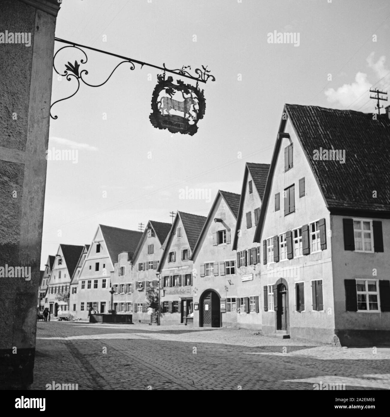 Geschäfte und Wohnhäuser in einer Straße in Dinkelsbühl, Deutschland 1930er Jahre. Shops and houses at a street in Dinkelsbuehl, Germany 1930s. Stock Photo