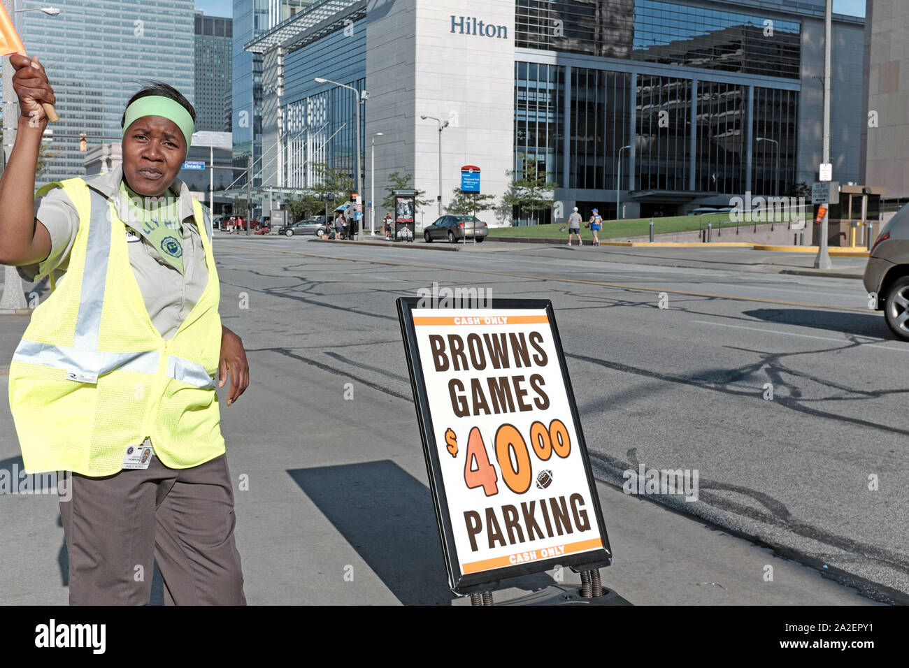 Cleveland Browns game day parking attendant on Lakeside Avenue waves people into the 40.00 dollar parking lot in downtown Cleveland, Ohio, USA. Stock Photo