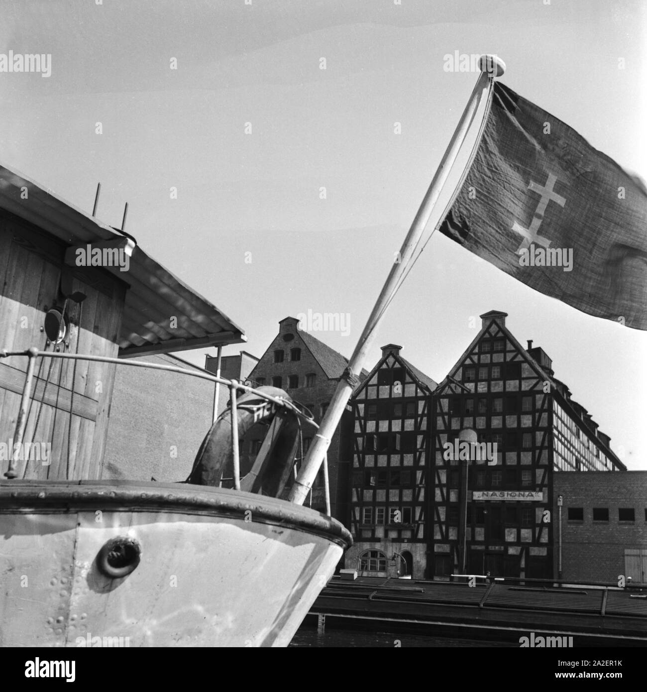 Speicherhäuser und Schiff mit Flagge im Hafen von Danzig, Deutschland 1930er Jahre. Warehouses and ship with flag at Danzig, Germany 1930s. Stock Photo
