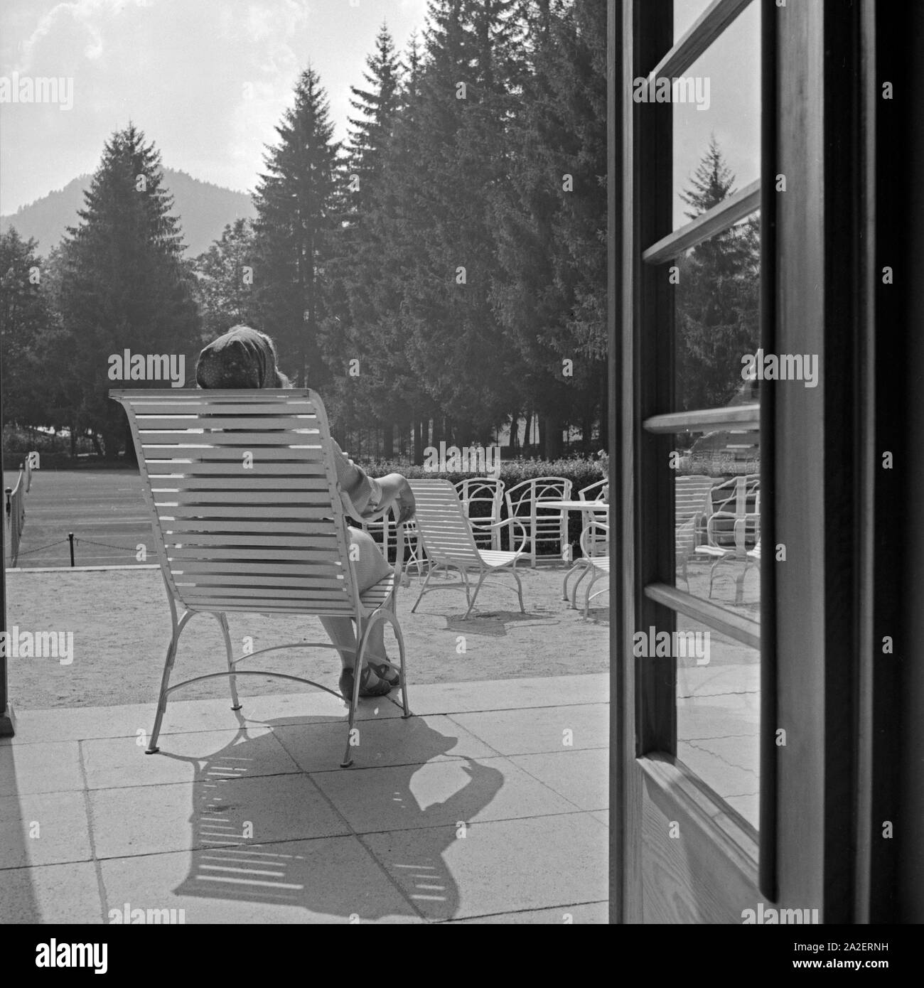 Eine Frau beim Sonnenbad auf der Terrasse am Kurhaus in Herrenalb im Schwarzwald, Deutschland 1930er Jahre. A woman sunbathing at the terrace of the spa resort at Herrenalb in Black Forest, Germany 1930s. Stock Photo