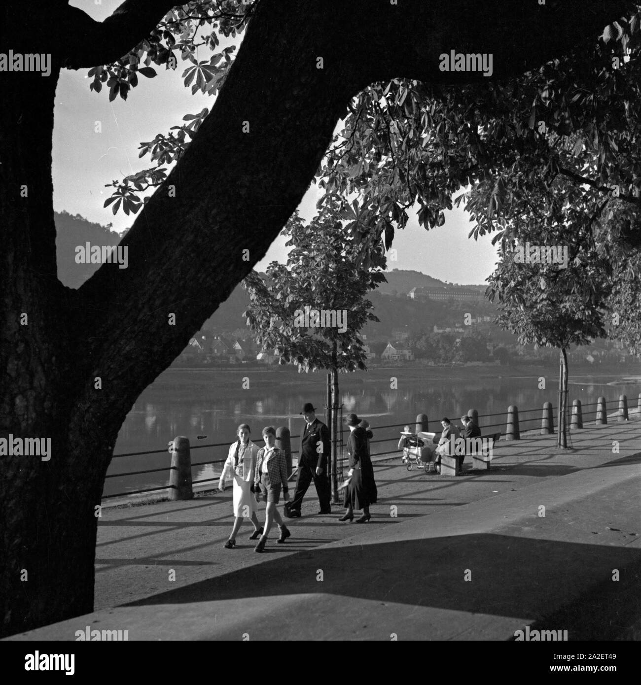 Passangen gehen am Ufer der Mosel in Trier spazieren, Deutschland 1930er Jahre. People strolling on the shre of river Moselle at Trier, Germany 1930s. Stock Photo