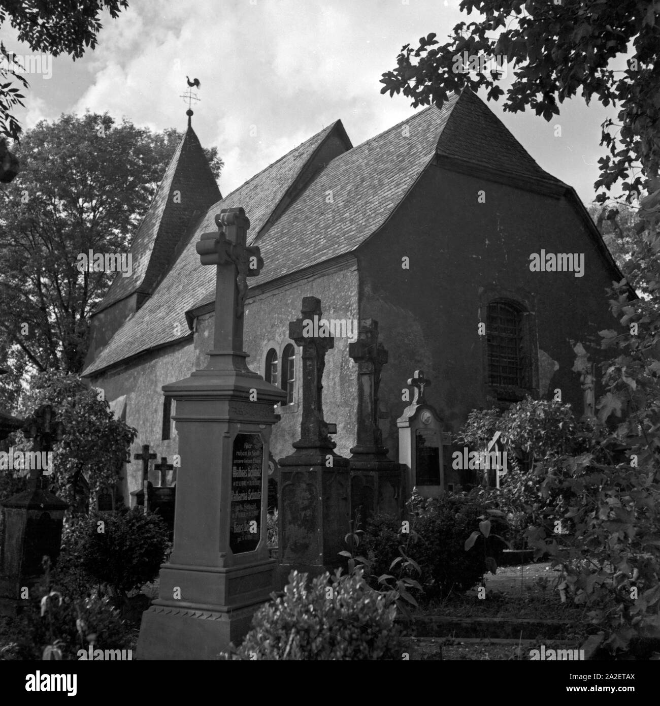 Blick auf die Kirche und den Friedhof in Weinfeld bei Daun in der Eifel, Deutschland 1930er Jahre. View to the church and the burial ground at Weinfeld near Daun at Eifel region, Germany 1930s. Stock Photo