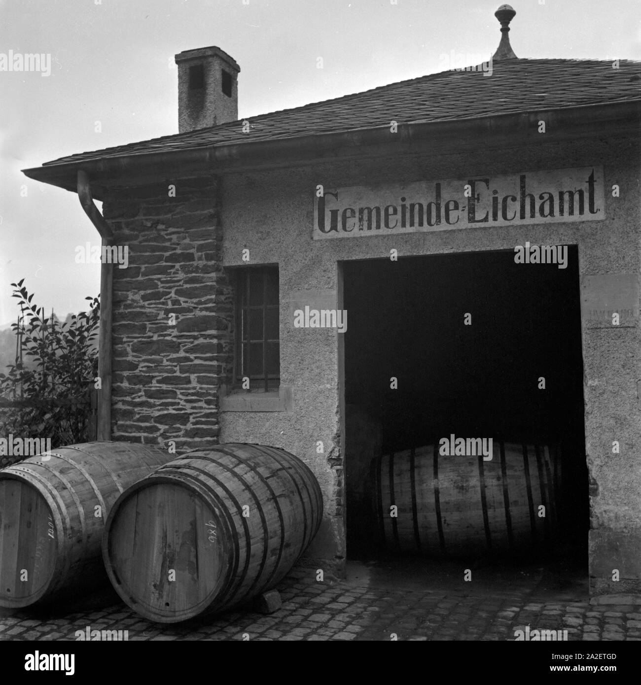 Fässer warten im Gemeinde Eichamt auf ihre Prüfung, Moseltal, Deutschland 1930er Jahre. Wine barrels waiting at the boards of weights and measures to be checked, Moselle valley, Germany 1930s. Stock Photo