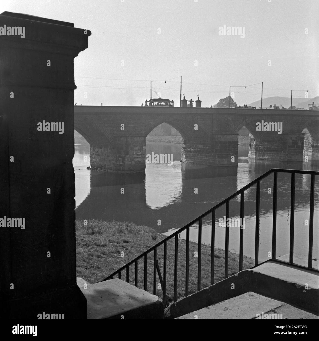 Straßenbahnen auf ihrem Weg über die Alte Moselbrücke in Trier, Deutschland 1930er Jahre. Trams on their way on the old bridge over river Moselle at Trier, Germany 1930s. Stock Photo