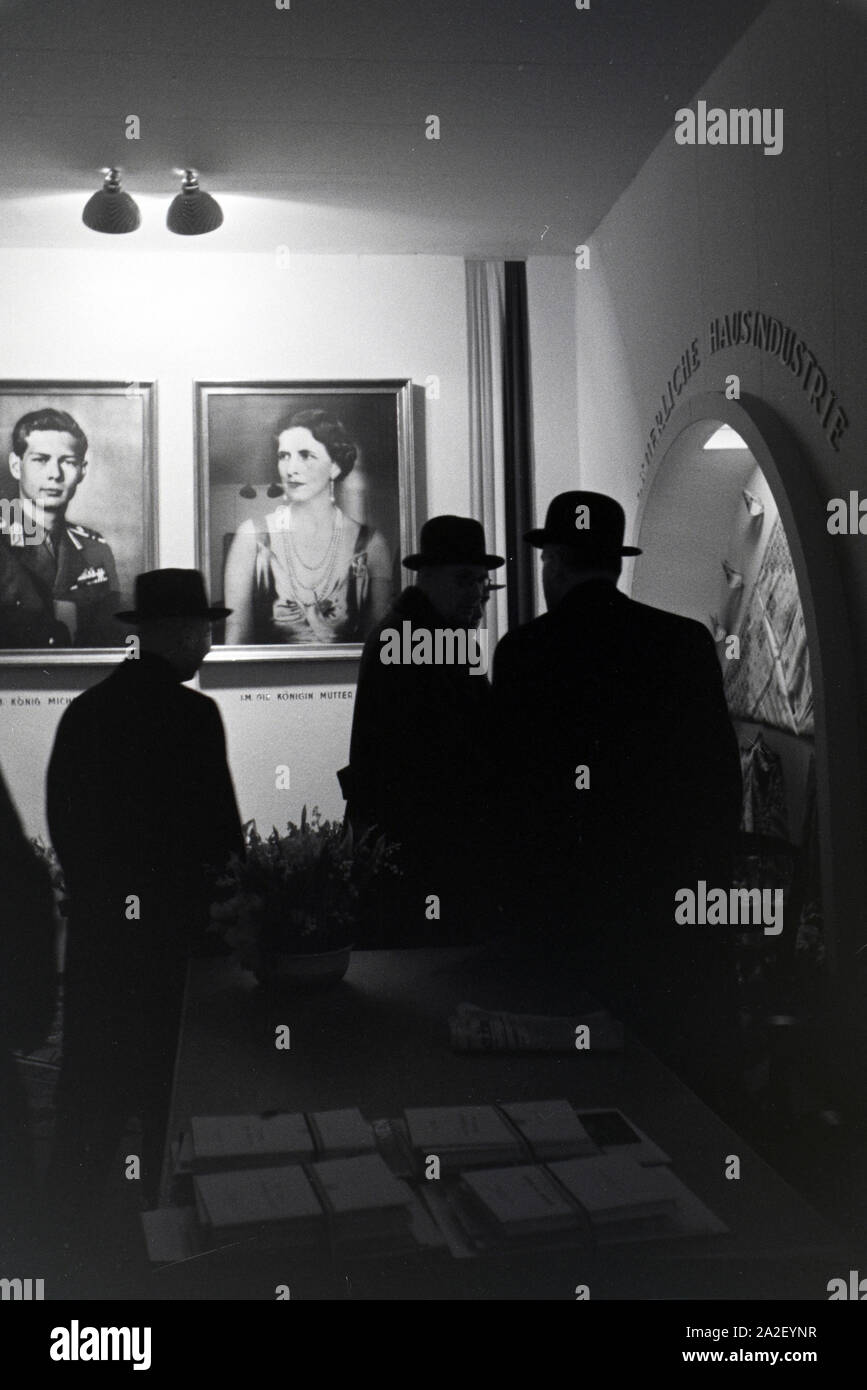 Besucher der Leipziger Frühjahrsmesse an einem rumänischen Stand mit Portraits des rumänischen Königs Michael I. und seiner Königinmutter Elena von Gr Stock Photo