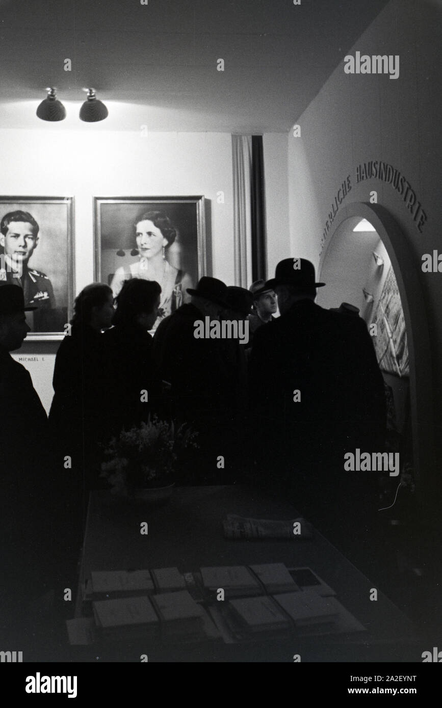 Besucher der Leipziger Frühjahrsmesse an einem rumänischen Stand mit Portraits des rumänischen Königs Michael I. und seiner Königinmutter Elena von Gr Stock Photo