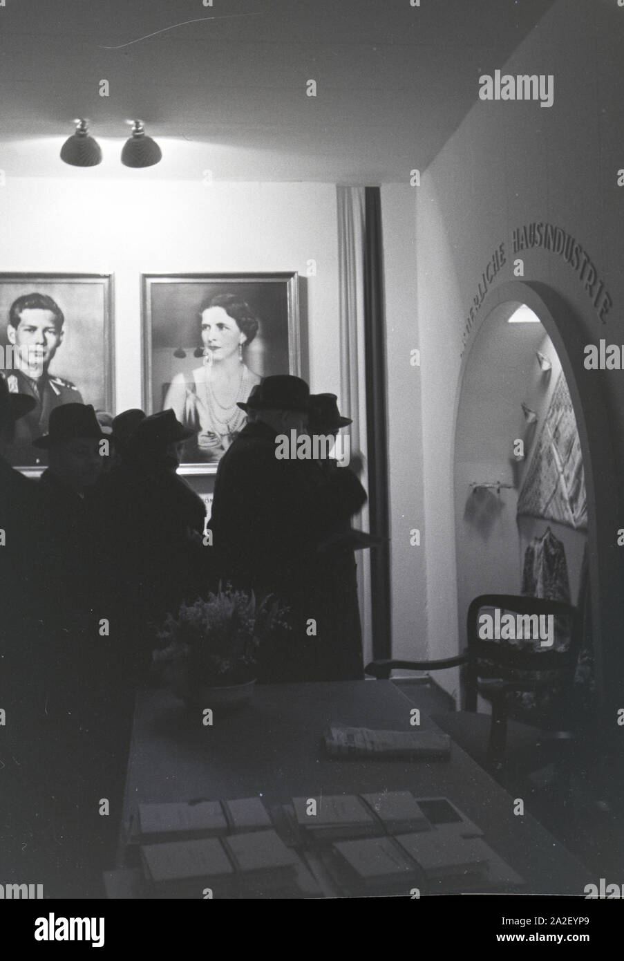 Besucher der Leipziger Frühjahrsmesse an einem rumänischen Stand mit Portraits des rumänischen Königs Michael I. und seiner Königinmutter Elena von Gr Stock Photo