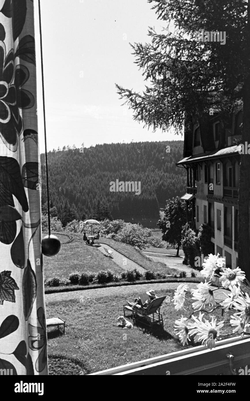 Eine junge Frau entspannt bei der Zeitschriftenlektüre im Garten, Freudenstadt, Deutschland 1930er Jahre. A young woman relaxing with a magazine in the garden, Freudenstadt, Germany 1930s. Stock Photo