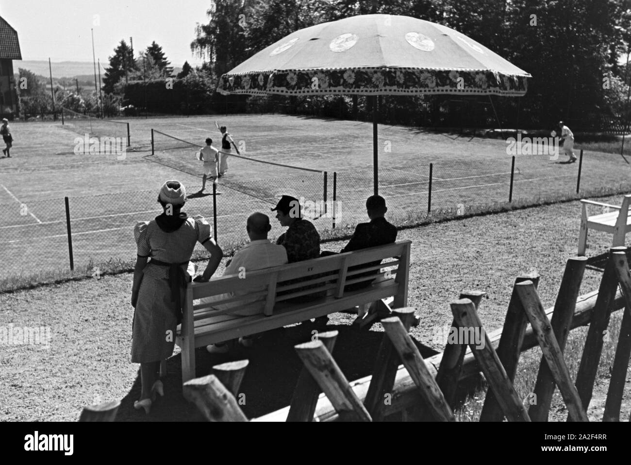 Tennisspieler bei einer Partie auf dem Spielfeld und ihr Publikum