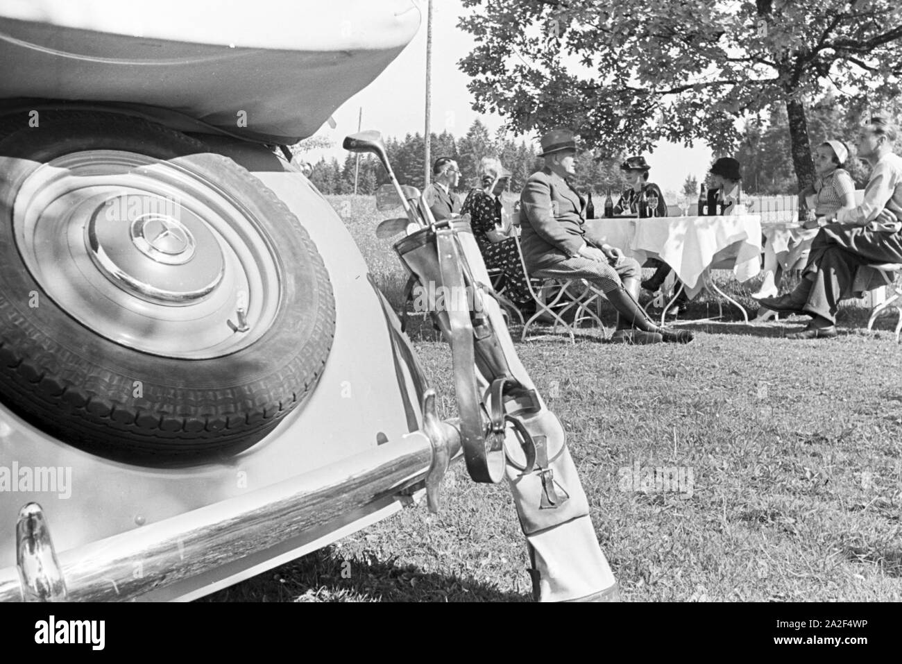 Die Zuschauer eines Golfspiels erfrischen sich mit Getränken, Freudenstadt, Deutschland 1930er Jahre. The audience of a game of golf are having a drink, Freudenstadt, Germany 1930s. Stock Photo