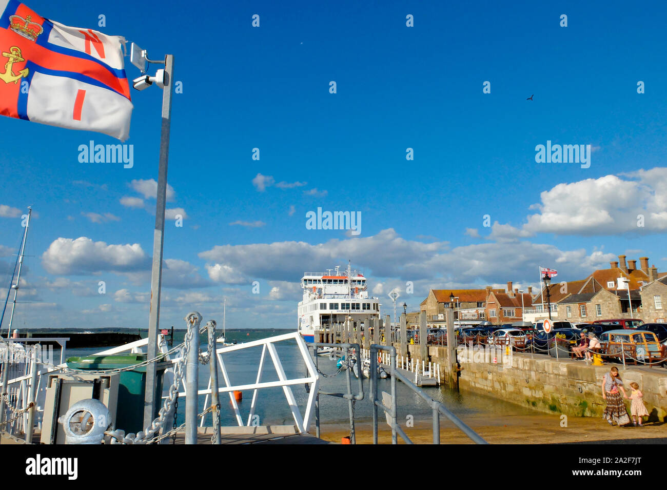 Yarmouth Harbour on the Isle of Wight showing Wightlink Ferry and the RNLI flag flying above the lifeboat station Stock Photo